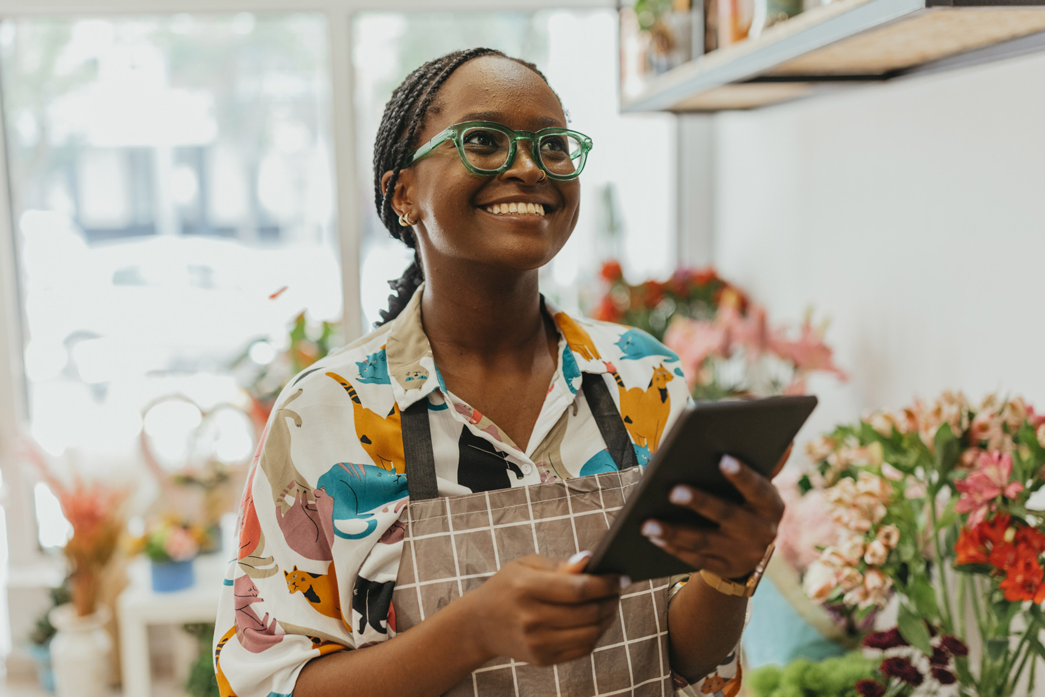 A young woman using a tablet device in a florist shop