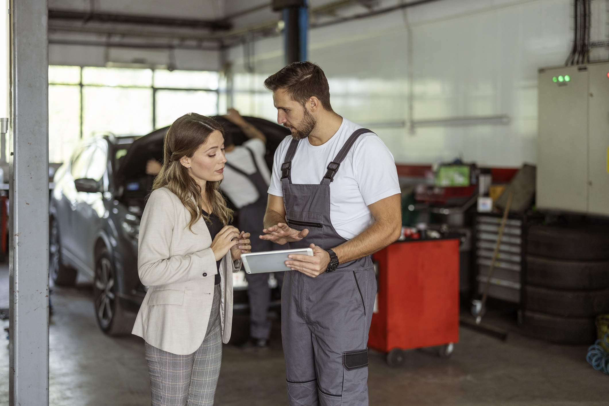 Mechanic showing customer something on a tablet