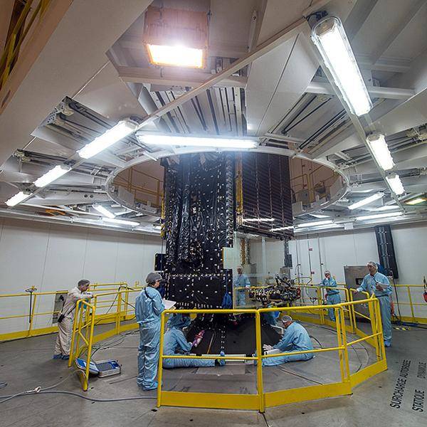 A team works behind a safety railing on nbn's Sky Muster Satellite before it's launched into space